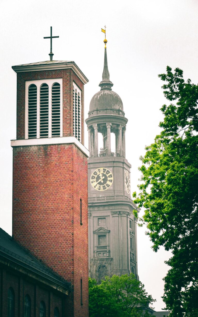 A stunning view of St. Michael's Church tower in Hamburg with lush greenery.