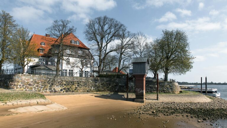 Peaceful riverside view of traditional architecture in Hamburg, Germany.