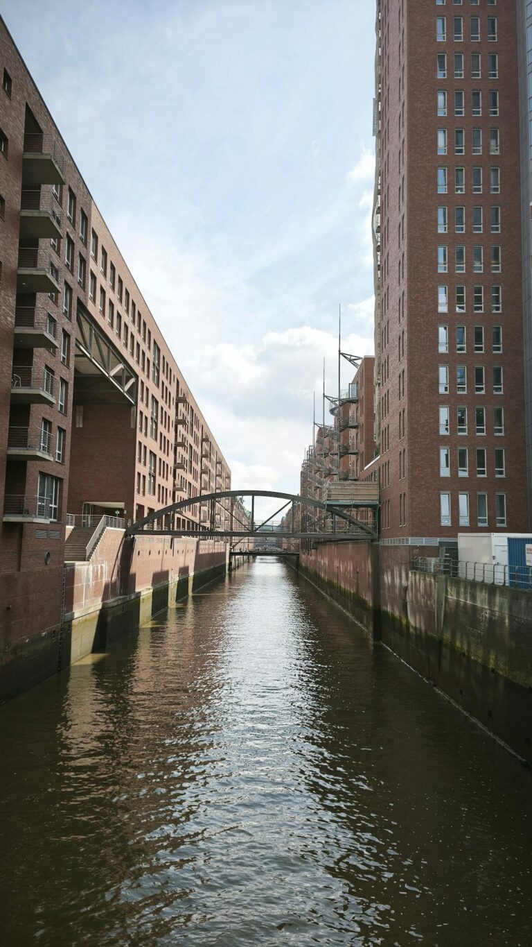 Stunning view of the iconic Speicherstadt canal, flanked by brick buildings and clear skies in Hamburg.